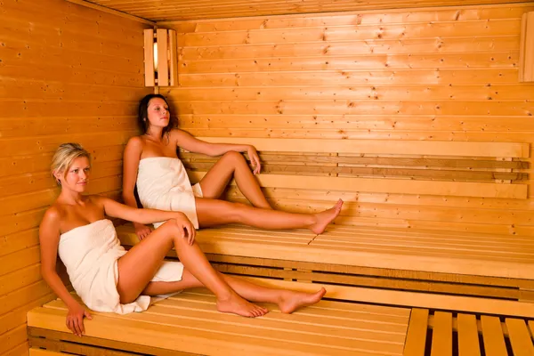 Sauna dvě ženy relaxační posezení zabalený ručník — Stock fotografie
