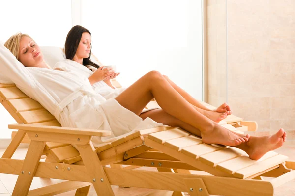 Luxe spa twee vrouwen ontspannen vergadering zon-bedden — Stockfoto