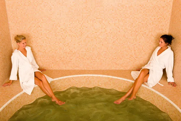 Détendez-vous spa piscine deux femmes assis peignoir — Photo