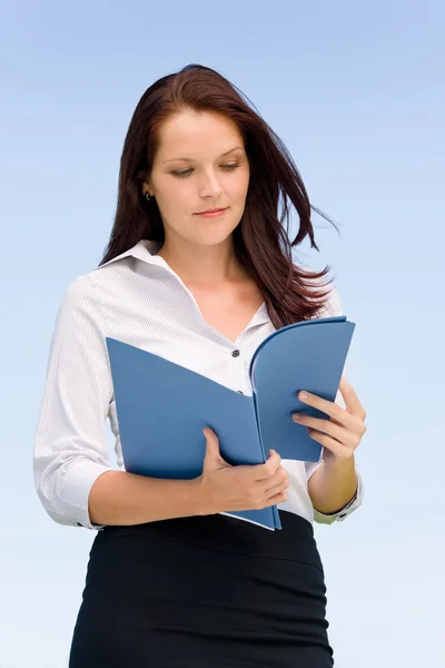 Businesswoman in sunny nature looking into folders — Stock Photo, Image