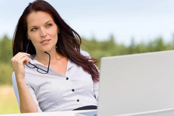 Mujer de negocios naturaleza soleada pensativa con el ordenador portátil — Foto de Stock
