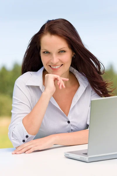Zakenvrouw in de zonnige natuur met laptop glimlach — Stockfoto