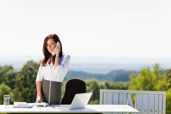 Businesswoman in sunny nature office calling — Stock Photo, Image