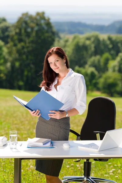 Businesswoman in sunny nature office look folder — Stock Photo, Image
