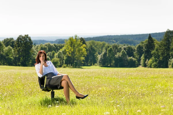 Aantrekkelijke zakenvrouw zitten leunstoel zonnige weide — Stockfoto
