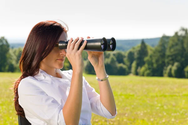 stock image Businesswoman sit in sunny meadow seek binocular