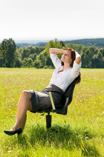 Genç iş kadını güneşli çayır relax koltuk üzerinde — Stok fotoğraf