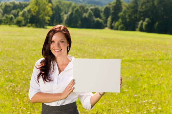 Businesswoman sunny meadow hold empty banner — Stock Photo, Image
