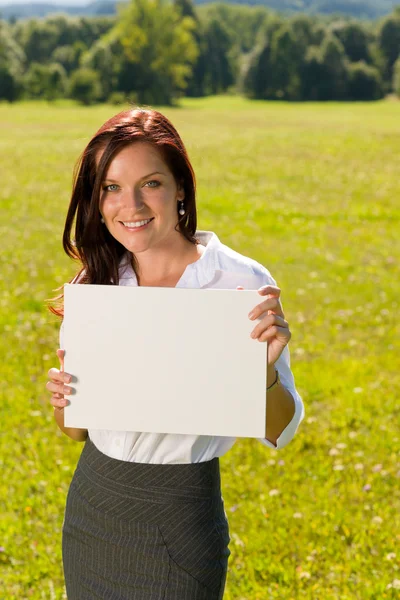 Businesswoman sunny meadow hold empty banner — Stock Photo, Image