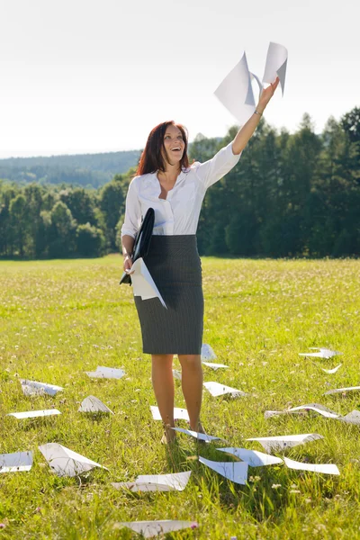 Femme d'affaires prairie ensoleillée jeter des papiers liberté — Photo