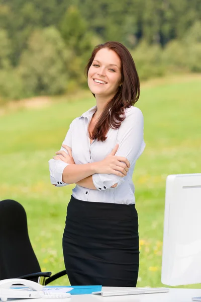 Mujer de negocios en la naturaleza soleada sonriendo brazos cruzados Fotos De Stock Sin Royalties Gratis