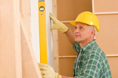 Handyman mature professional with spirit level clipart