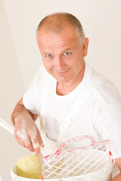 Homme d'âge mûr avec rouleau à peinture de décoration à la maison — Photo
