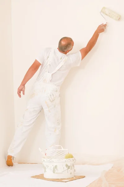 Homme d'âge mûr avec rouleau à peinture de décoration à la maison — Photo