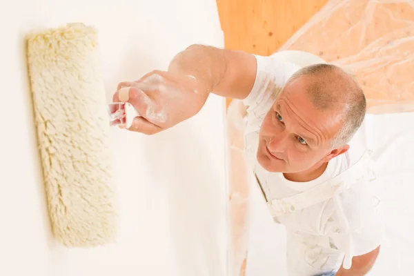 Home decorazione uomo maturo pittura parete rullo — Foto Stock