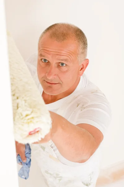 Home decorating mature man painting wall roller — Stock Photo, Image