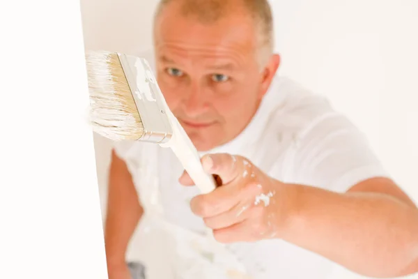 Heminredning mogen man måla väggen borste — Stockfoto