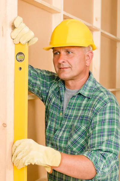 Handyman mature professional with spirit level — Stock Photo, Image