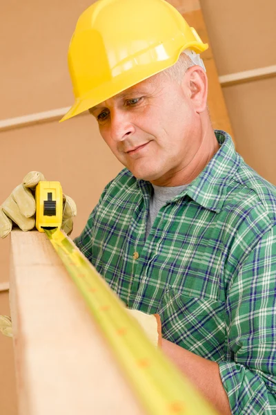 Handyman maduro carpinteiro medida feixe de madeira — Fotografia de Stock