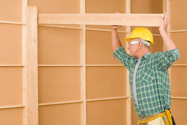 Handyman carpenter mature fitting wooden beam — Stock Photo, Image