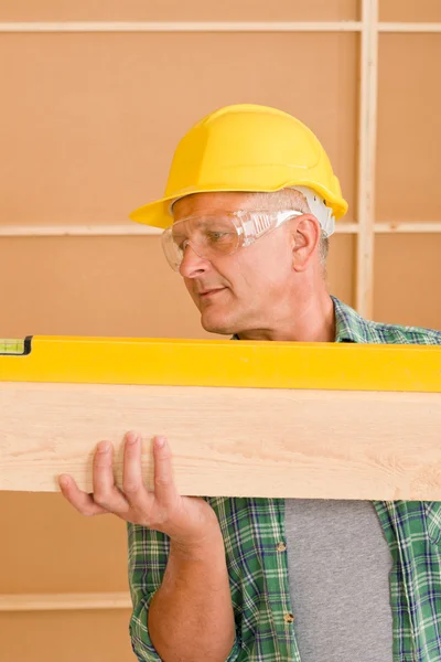 Handyman mature professional with spirit level — Stock Photo, Image