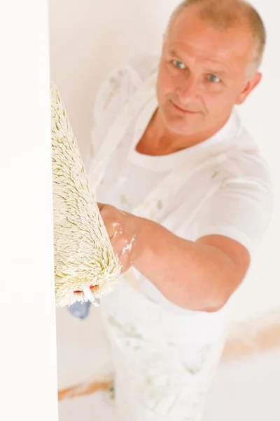 Home decorating mature man painting wall roller Stock Image