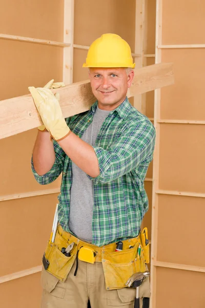 Handyman carpenter mature carry wooden beam Stock Image