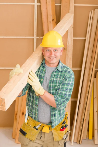 Handyman carpenter mature carry wooden beam Stock Photo