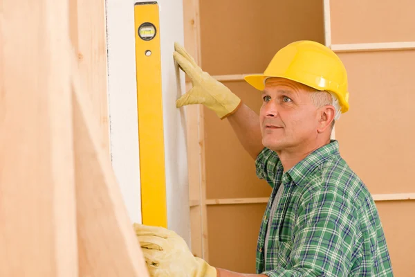 Handyman mature professional with spirit level Stock Picture