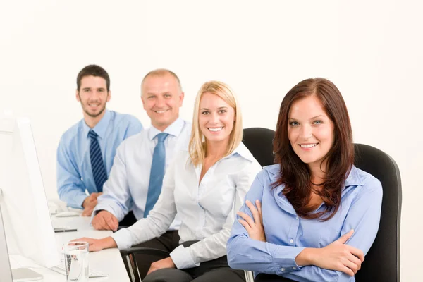 Verksamhet team glad sitter i raden bakom tabell — Stockfoto