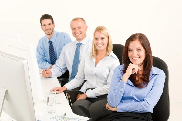 Equipe de negócios feliz sentar na fila atrás da mesa — Fotografia de Stock