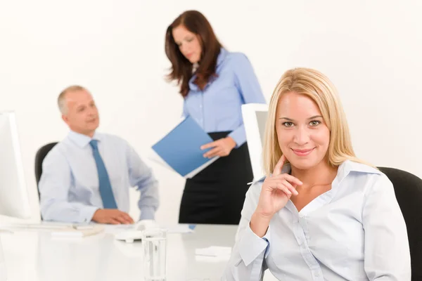Geschäftsfrau mit hübschem Lächeln sitzt in Bürokollegin lizenzfreie Stockfotos