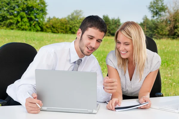 Affärskollegor i naturen med laptop leende — Stockfoto