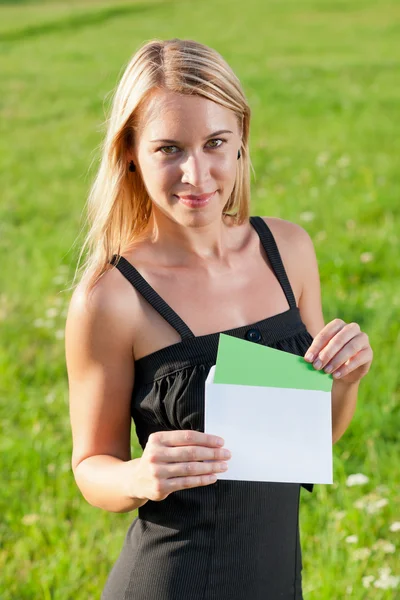 Niespodzianka koperta młoda kobieta słoneczna łąka — Zdjęcie stockowe