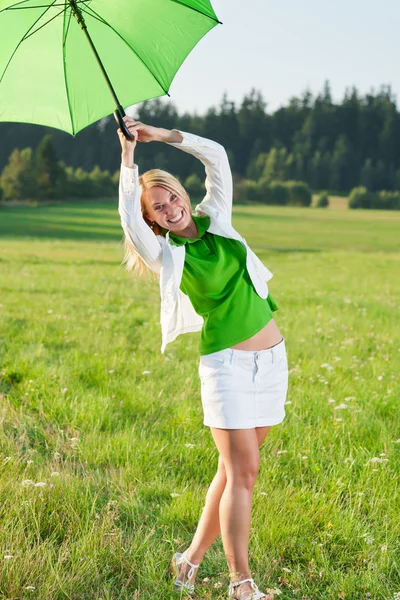 Glad ung kvinna med grönt paraply ängar — Stockfoto