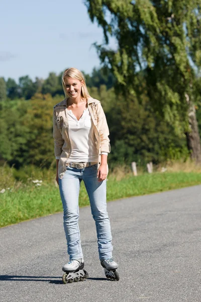 Patinaje en línea mujer joven en camino asfaltado soleado — Foto de Stock