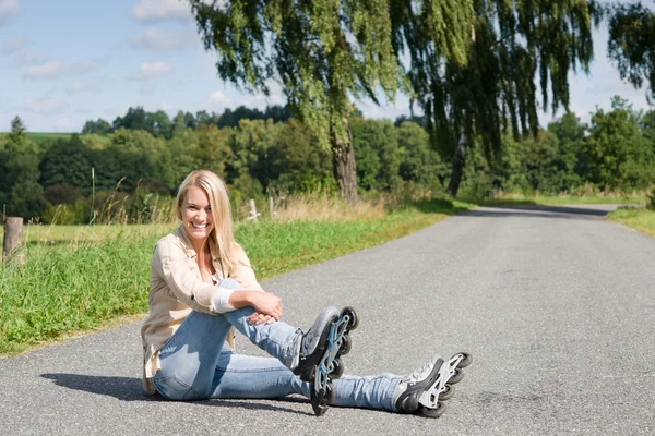 Inline skridskor ung kvinna sitter asfalterad väg — Stockfoto