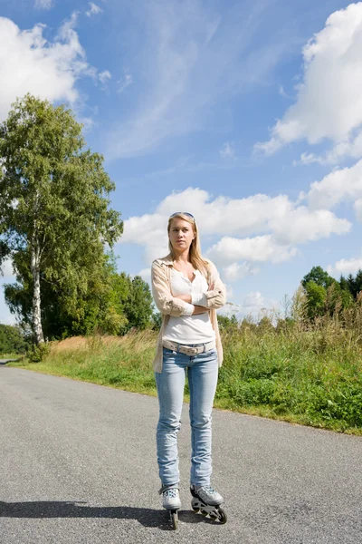Inline skating young woman on sunny asphalt road — Stock Photo, Image