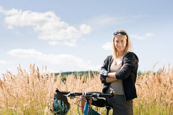 Bicicleta de montaña joven mujer deportiva prados soleados — Foto de Stock