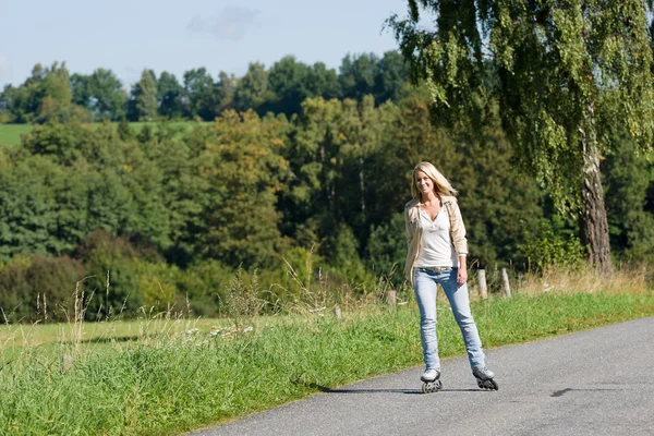 Inline schaatsen jonge vrouw op zonnige asfaltweg — Stockfoto
