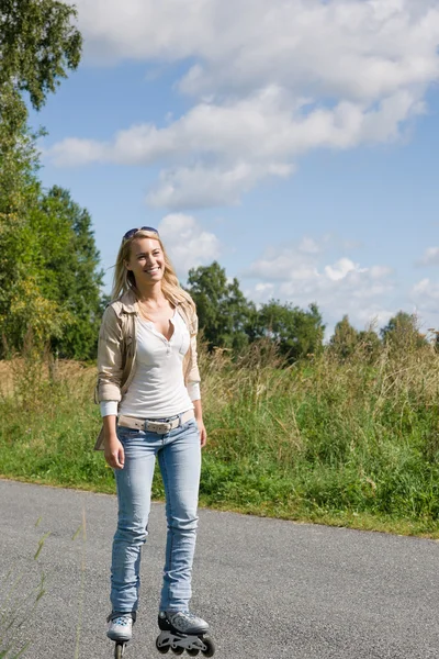 Inline bruslení mladou ženu na slunné asfaltové silnici — Stock fotografie