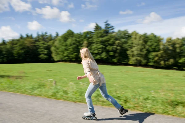 Patinaje en línea mujer joven entrenamiento de velocidad soleado — Foto de Stock