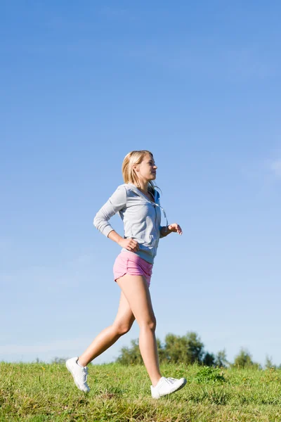 Jogging joven deportivo mujer prados día soleado — Foto de Stock