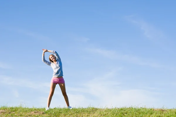 Растягивание молодой спортивной женщины луга солнечный день — стоковое фото