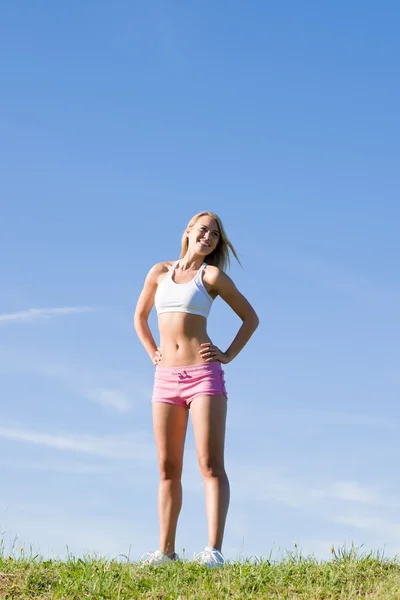 Protahovací mladá žena sportive louky slunečný den — Stock fotografie