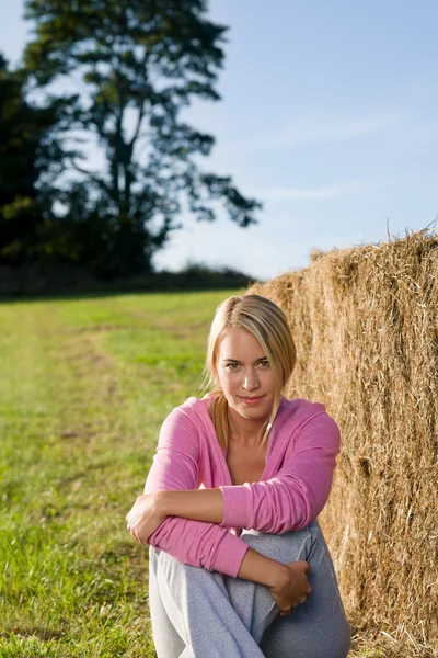 Sportive young woman relax by bales sunset — Stock Photo, Image