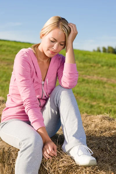 Sportive young woman relax on bales sunset — Stock Photo, Image
