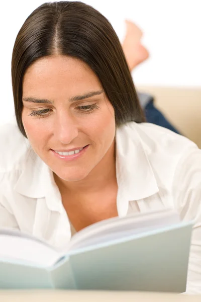 Atraktivní žena střední-věku číst knihu na pohovce — Stock fotografie