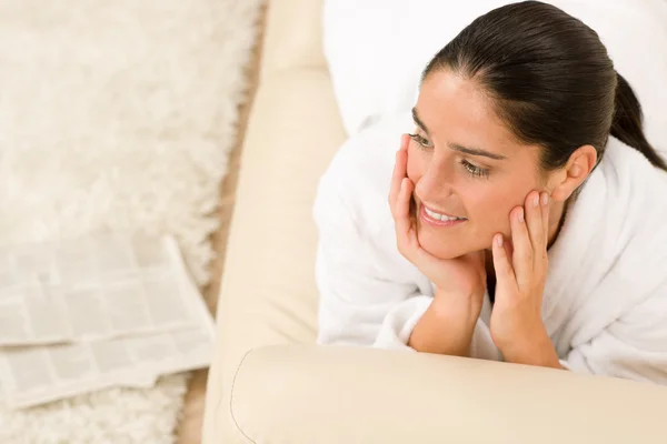 Mulher atraente roupão de banho branco no sofá pensando — Fotografia de Stock