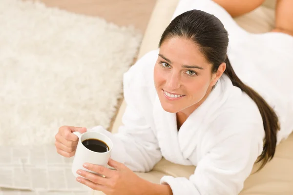 Attraktiv kvinna i vit morgonrock på soffa — Stockfoto
